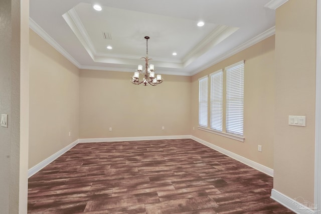 spare room with a chandelier, ornamental molding, dark hardwood / wood-style flooring, and a raised ceiling