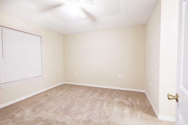 empty room featuring a textured ceiling, light carpet, and ceiling fan