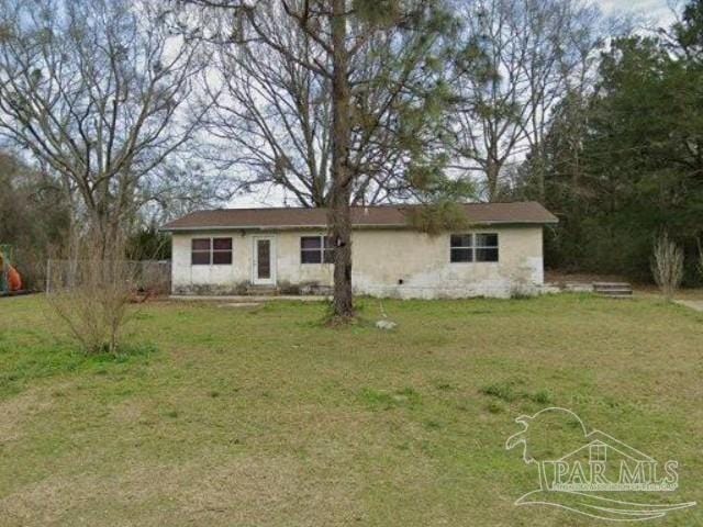 rear view of property with a lawn and fence