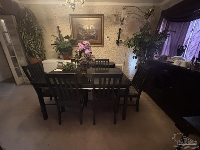 dining area with wallpapered walls and an inviting chandelier