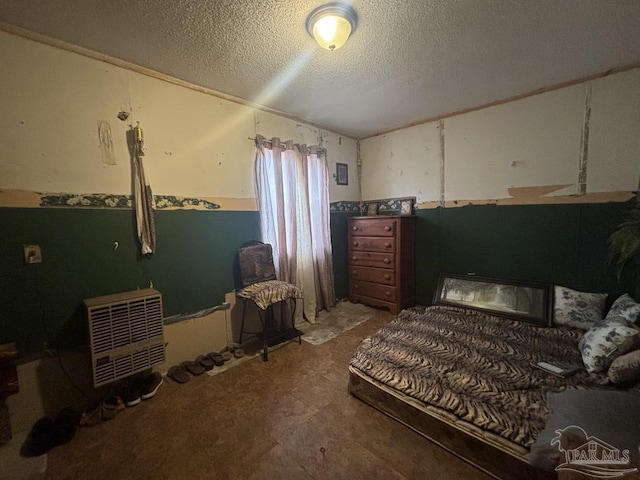 bedroom with heating unit and a textured ceiling