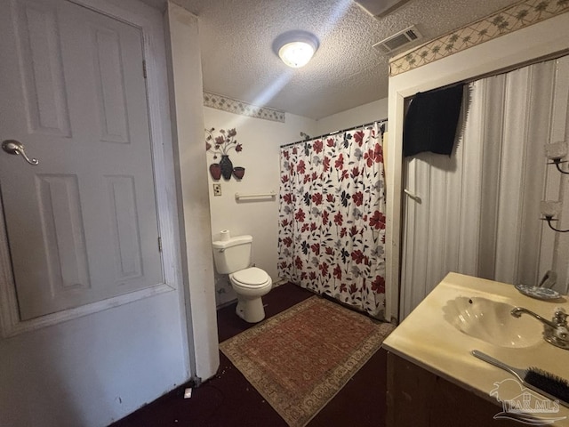 full bath featuring vanity, toilet, visible vents, and a textured ceiling