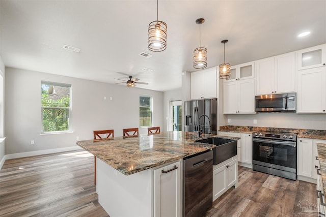 277 Seamarge Ln, Pensacola, FL 32507 - kitchen featuring stainless steel appliances, a sink, wood finished floors, an island with sink, and recessed lighting