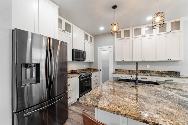 277 Seamarge Ln, Pensacola, FL 32507 - kitchen with black appliances, a sink, decorative light fixtures, white cabinetry, and wood finished floors
