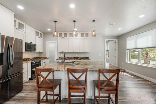 277 Seamarge Ln, Pensacola, FL 32507 - kitchen featuring black appliances, a sink, dark wood-style flooring, recessed lighting, and a breakfast bar