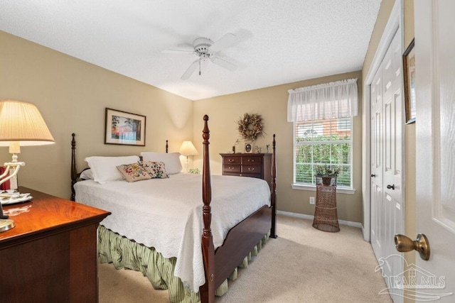 carpeted bedroom with ceiling fan, a closet, and a textured ceiling