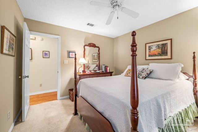 bedroom with light carpet, a textured ceiling, and ceiling fan