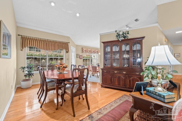 dining area featuring a textured ceiling and light hardwood / wood-style flooring