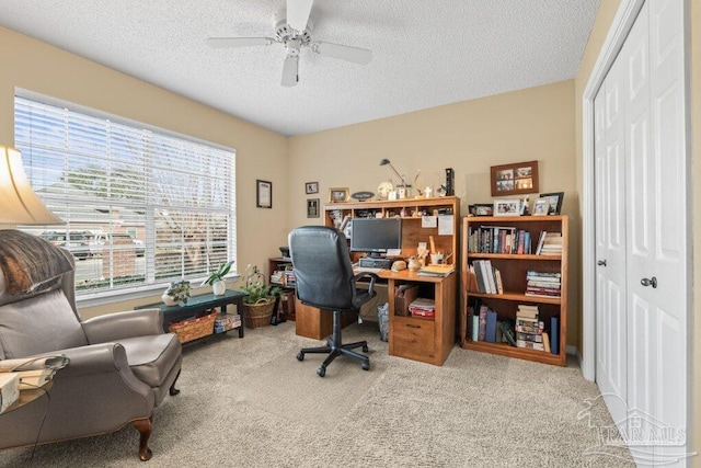 office area with ceiling fan, light colored carpet, and a textured ceiling