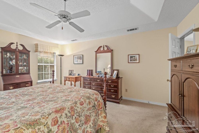 carpeted bedroom featuring ceiling fan and a textured ceiling