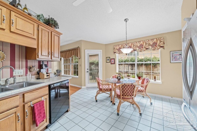 kitchen featuring sink, hanging light fixtures, light tile patterned floors, stainless steel refrigerator, and dishwasher