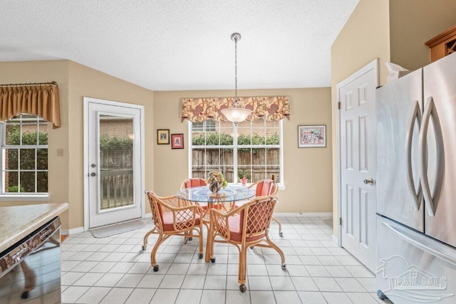 dining area with light tile patterned floors and a textured ceiling