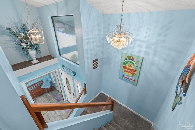stairs with carpet and a chandelier