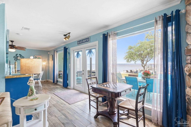 interior space with ornamental molding, french doors, ceiling fan, and wood finished floors