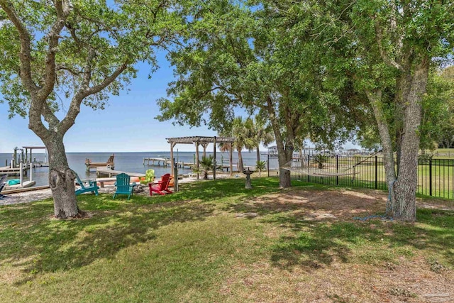 view of yard with a water view, a pergola, and fence