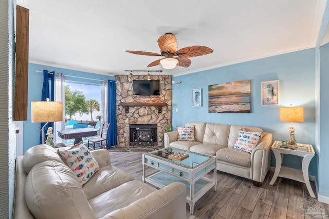 living room with baseboards, crown molding, ceiling fan, and wood finished floors