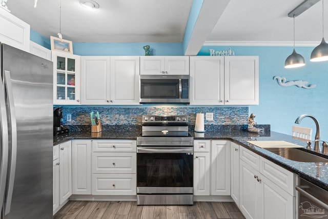 kitchen featuring backsplash, stainless steel appliances, white cabinets, and a sink