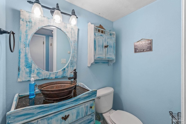 half bath featuring vanity and toilet