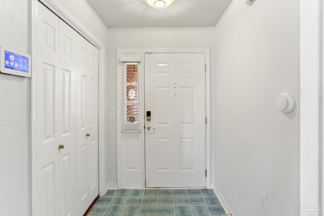 5541 Shadow Grove Blvd, Pensacola, FL 32526 - entrance foyer with dark tile patterned floors, baseboards, and a textured ceiling
