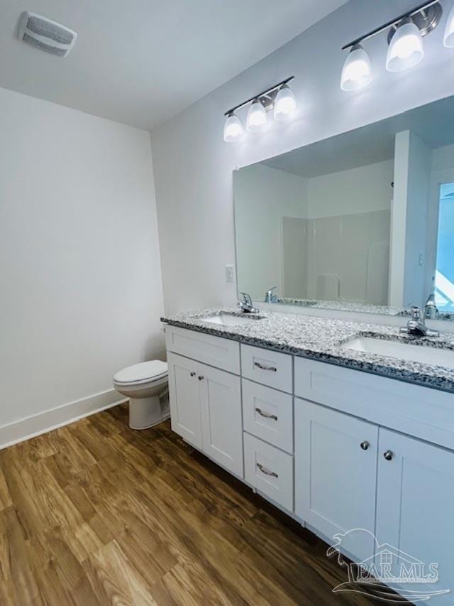 bathroom with vanity, toilet, and wood-type flooring