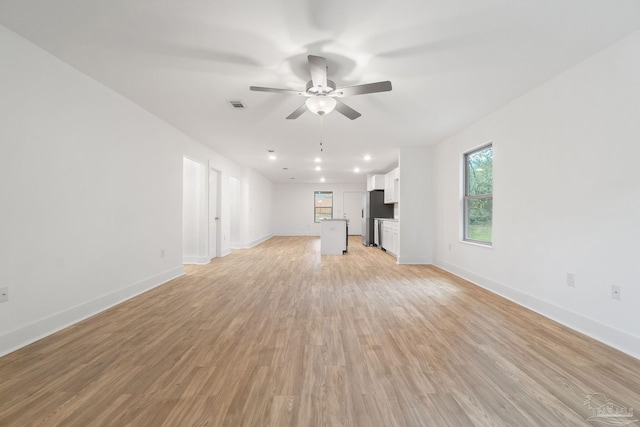 unfurnished living room with light hardwood / wood-style flooring and ceiling fan