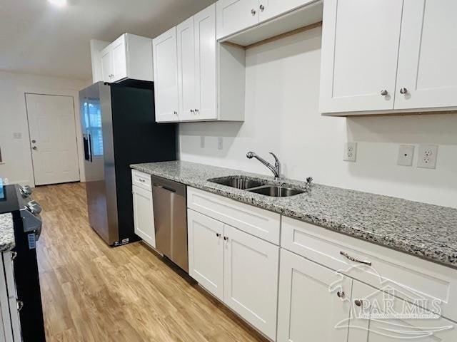 kitchen featuring light hardwood / wood-style flooring, white cabinetry, sink, and stainless steel appliances