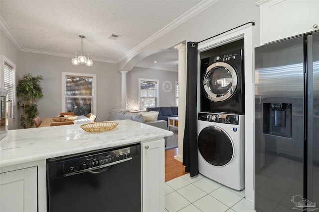 washroom featuring ornate columns, ornamental molding, stacked washer and clothes dryer, light tile patterned floors, and a textured ceiling