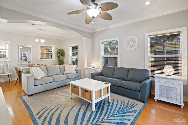 living room featuring ornamental molding, a wealth of natural light, and light wood-type flooring