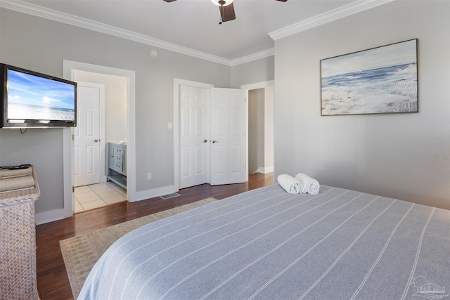 bedroom featuring wood-type flooring, ensuite bathroom, ceiling fan, and crown molding