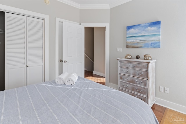 bedroom with crown molding, a closet, and hardwood / wood-style flooring