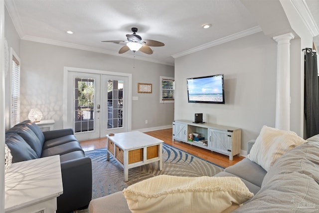 living room featuring hardwood / wood-style flooring, ornamental molding, decorative columns, and french doors