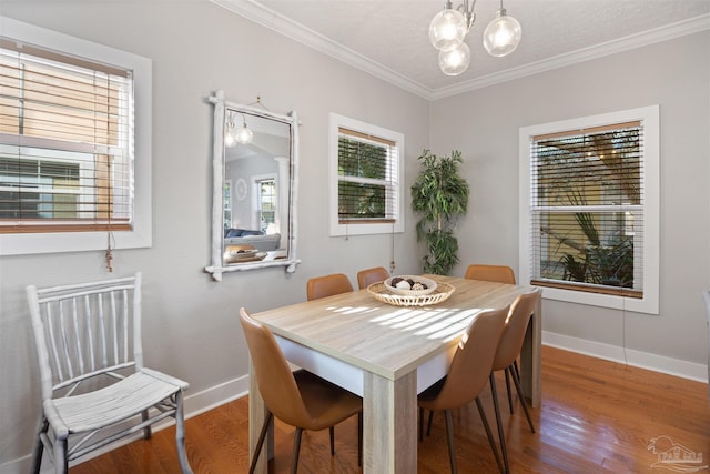 dining space featuring hardwood / wood-style floors, a notable chandelier, and ornamental molding