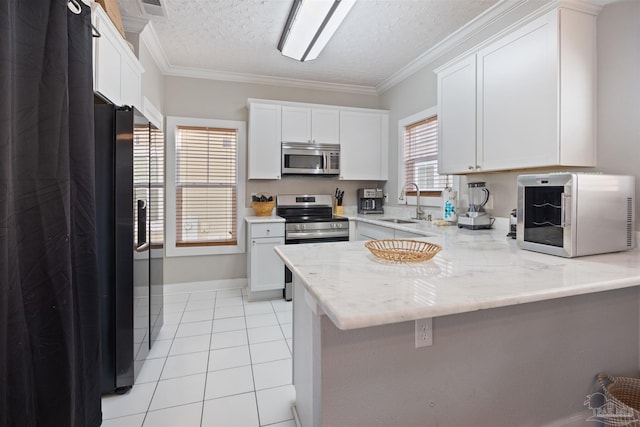 kitchen with light tile patterned flooring, white cabinets, ornamental molding, stainless steel appliances, and light stone countertops