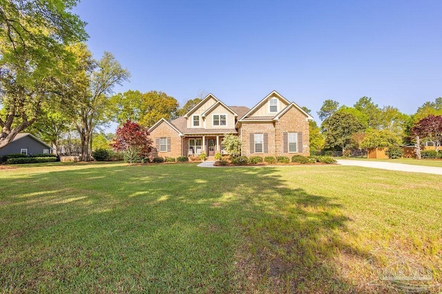 craftsman inspired home featuring brick siding and a front yard