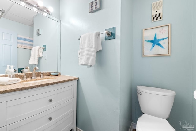 bathroom with toilet, visible vents, and vanity