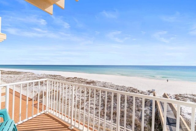 balcony featuring a view of the beach and a water view