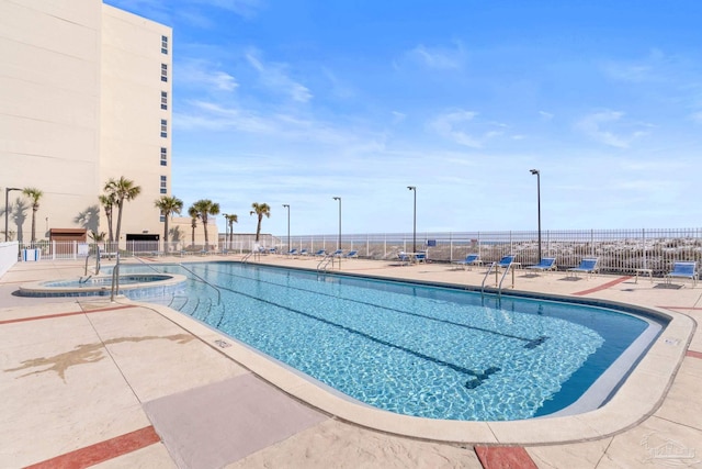 community pool featuring a patio area and fence