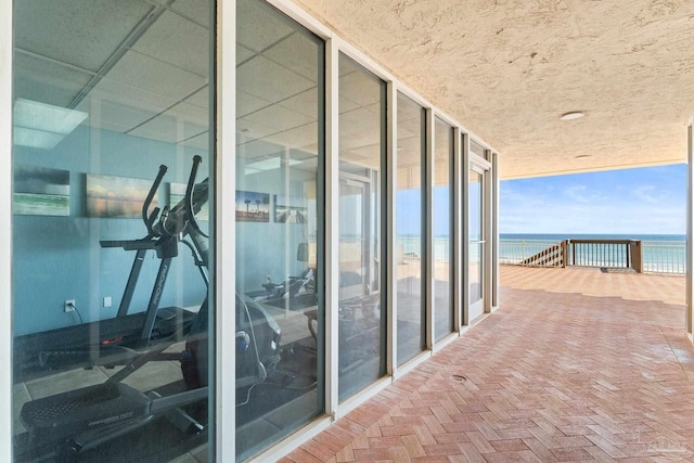 balcony featuring a water view and a beach view