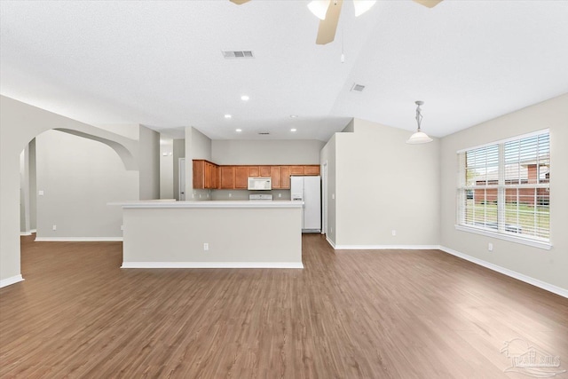 kitchen with dark wood-type flooring, hanging light fixtures, a textured ceiling, ceiling fan, and white appliances