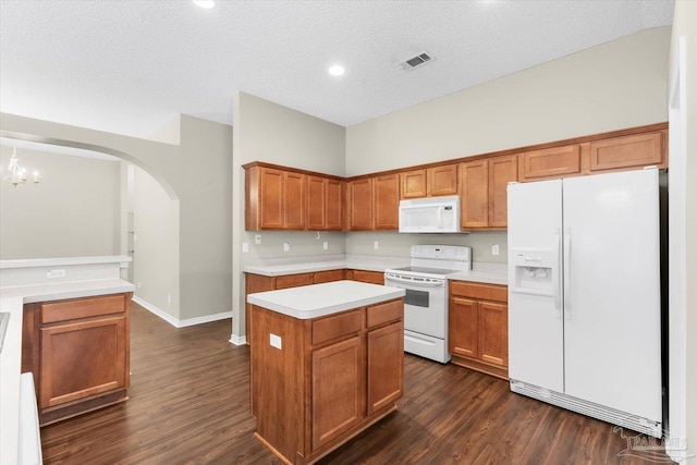 kitchen with a kitchen island, dark wood-type flooring, a textured ceiling, and white appliances