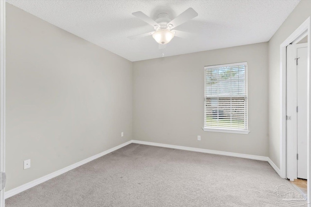 unfurnished bedroom featuring ceiling fan, light colored carpet, and a textured ceiling