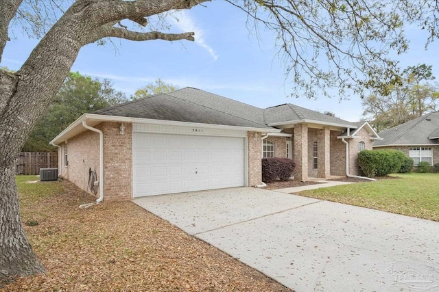 view of front of property featuring cooling unit, a garage, and a front lawn