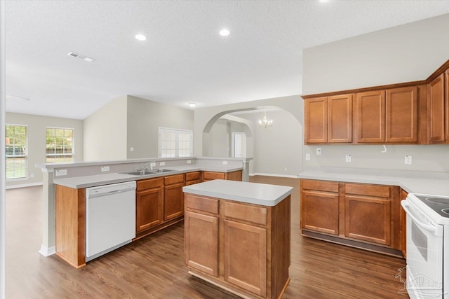 kitchen featuring dark hardwood / wood-style flooring, sink, white appliances, and a kitchen island