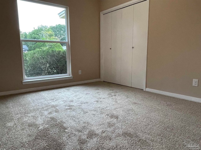 unfurnished bedroom featuring carpet flooring and a closet