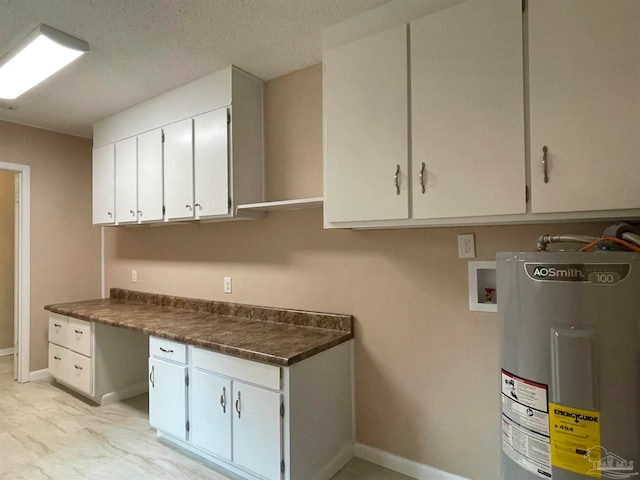 clothes washing area featuring cabinets, washer hookup, a textured ceiling, and water heater