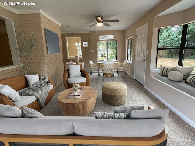 living room featuring ceiling fan, carpet floors, and brick wall