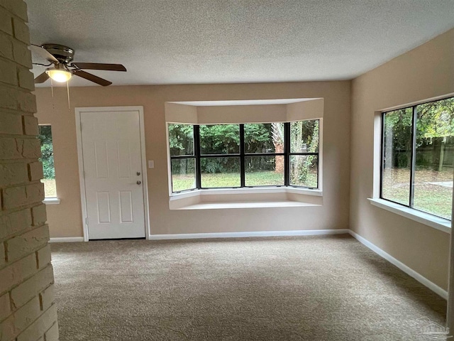 empty room with light carpet, a textured ceiling, and ceiling fan