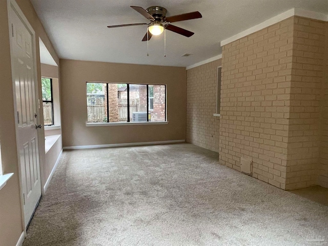 carpeted empty room with ceiling fan, cooling unit, a textured ceiling, and brick wall