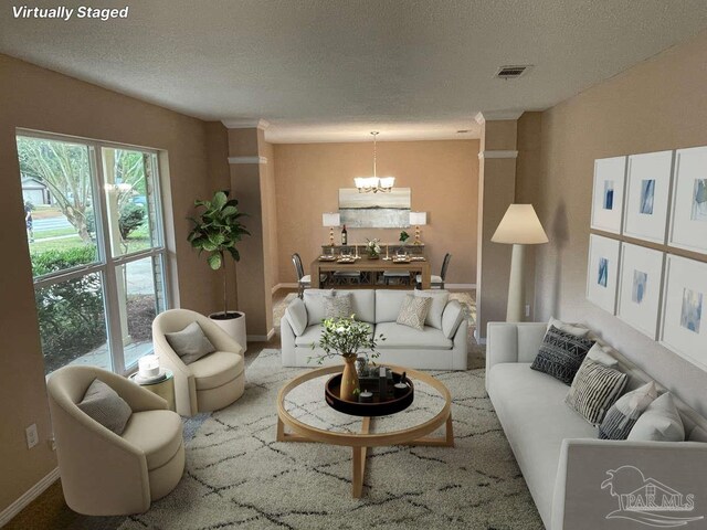 living room featuring a chandelier, a textured ceiling, and carpet floors