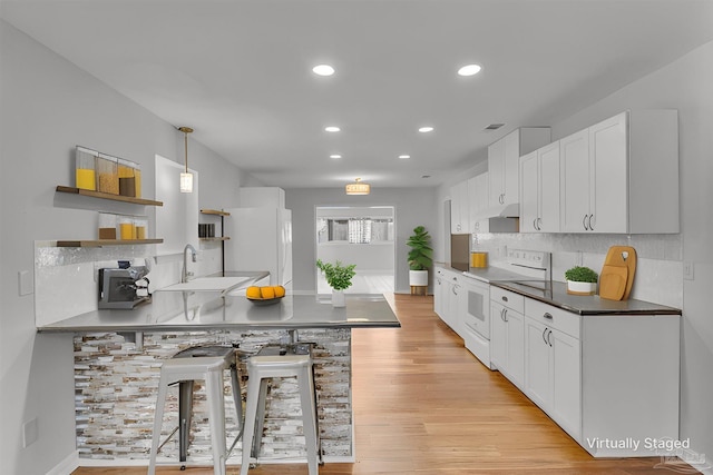 kitchen featuring open shelves, light wood-style flooring, a sink, white appliances, and under cabinet range hood